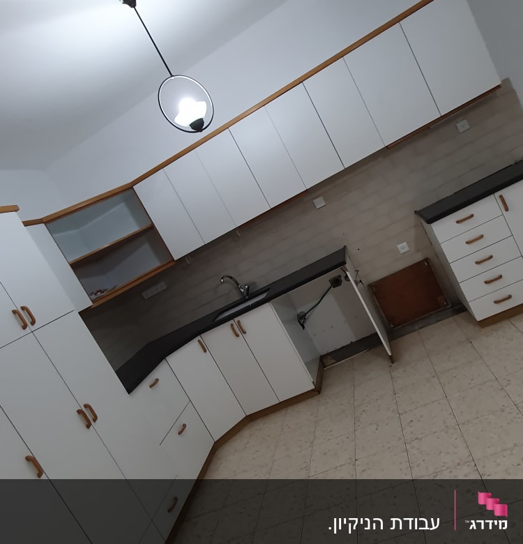 מטבח עם ארונות לבנים וכיור נקי